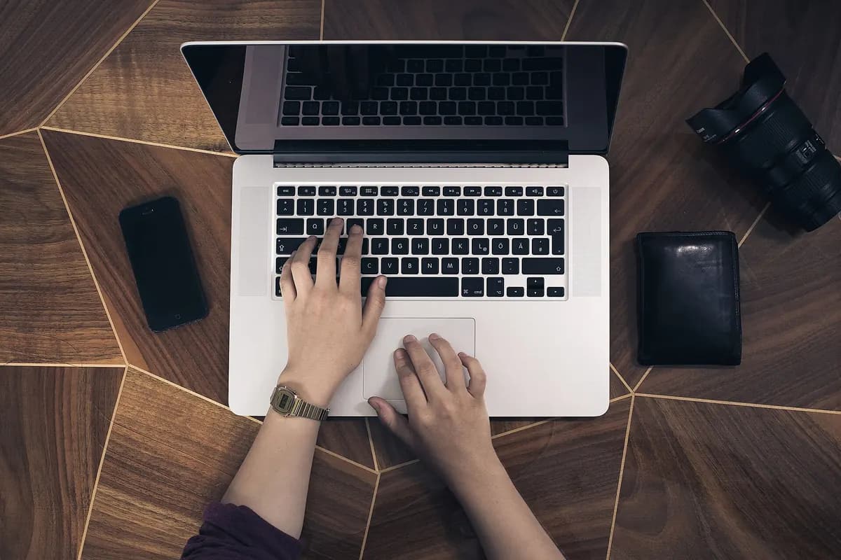 Hands typing on a laptop keyboard while choosing which public playlist to load
