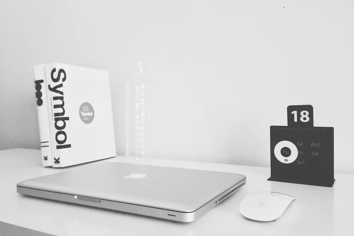 A laptop on a white desk, the kind of computer used to run a playlist checking tool
