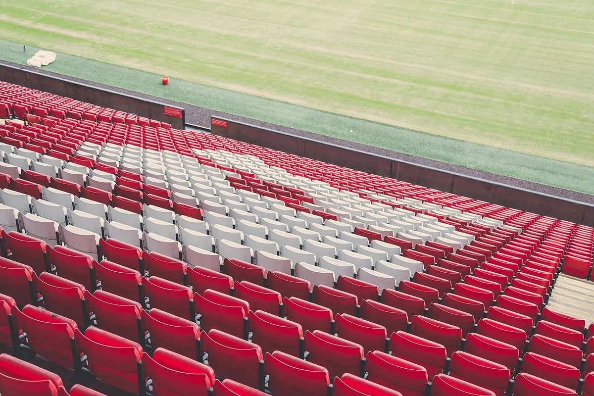 A football stadium with red seats, home of Premier League matches watched worldwide