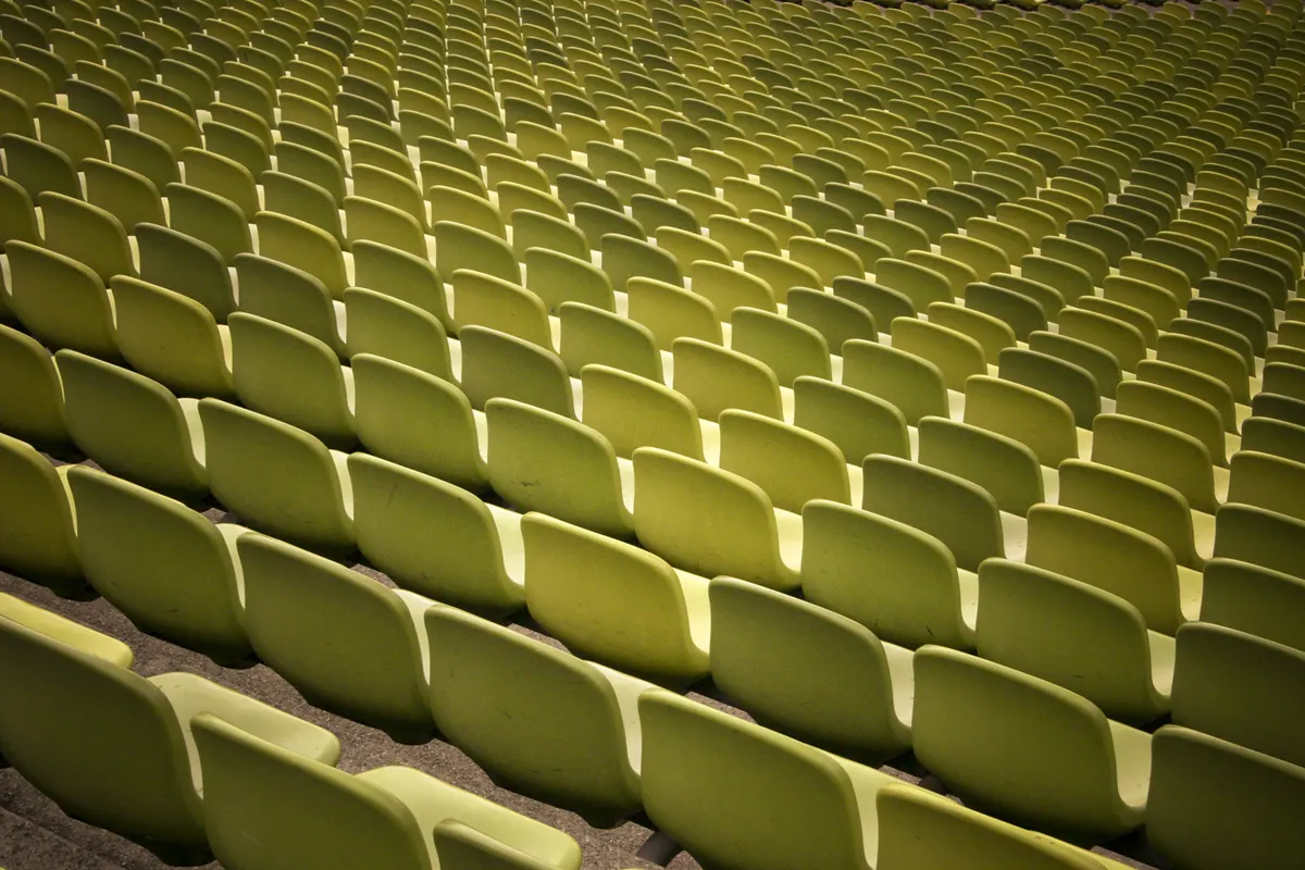 Rows of empty stadium seats before a football match broadcast