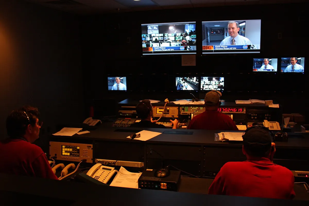A studio control desk with monitors, similar to a building's TV headend room